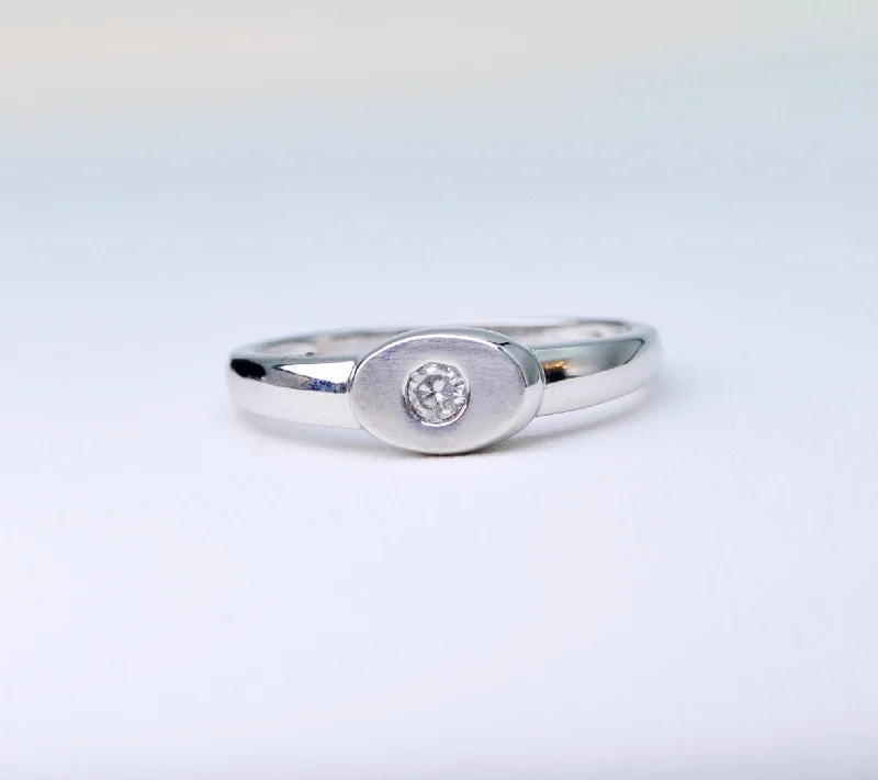 Pure charm rings-18K white gold ring with one small diamond set in an oval surface